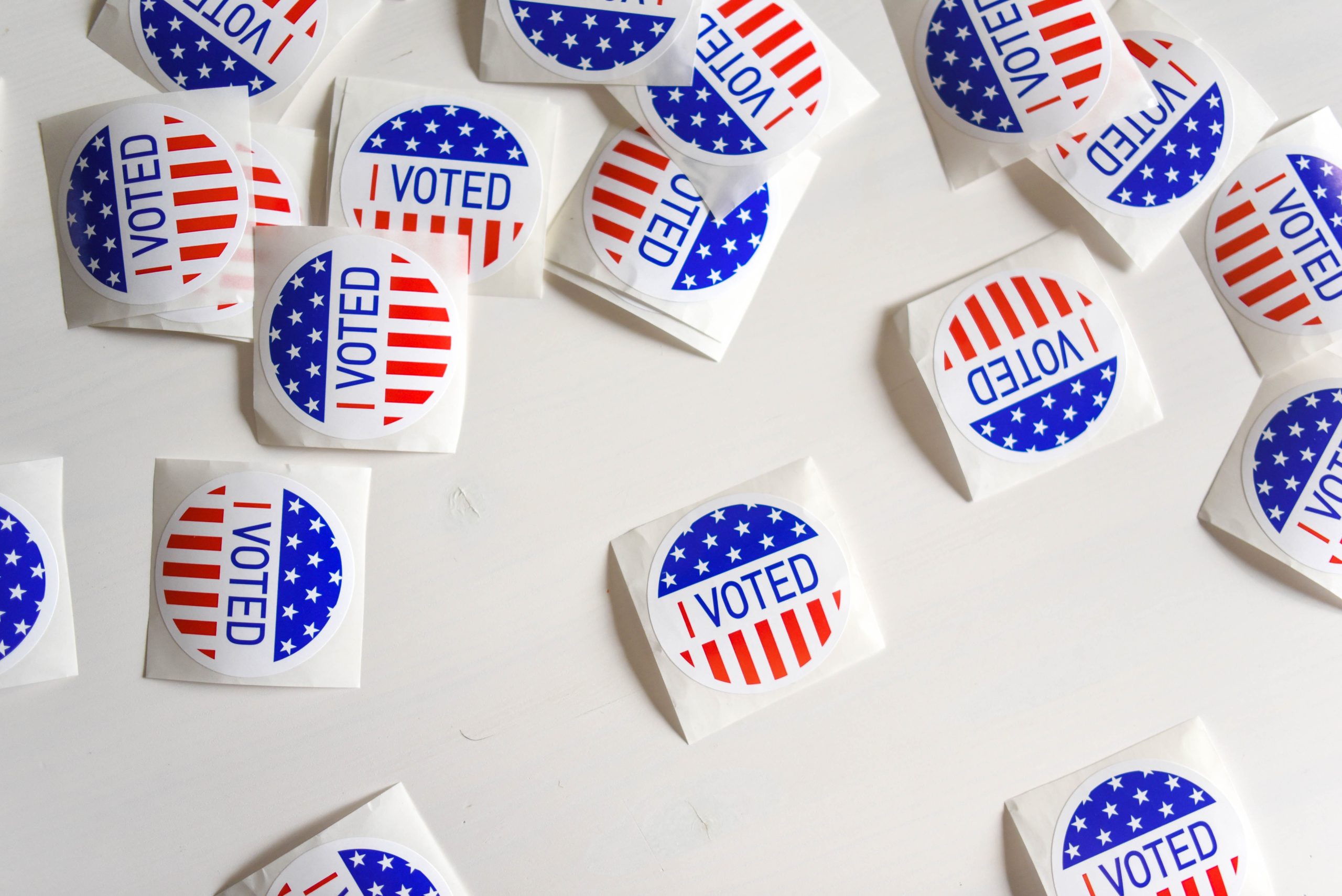 Red, white, and blue "vote" stickers scattered on a table.