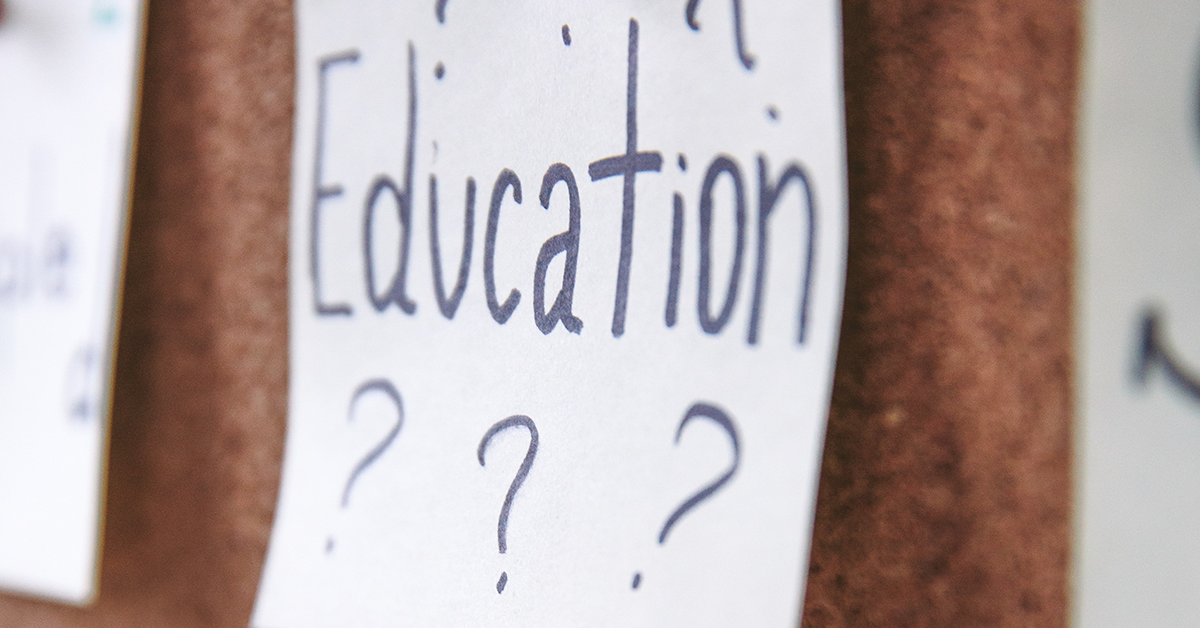 A note pinned to a bulletin board reads "Education???"
