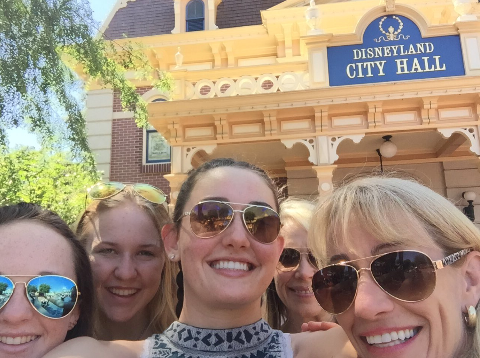 A group of people taking a City Hall Selfie outside Disneyland City Hall.