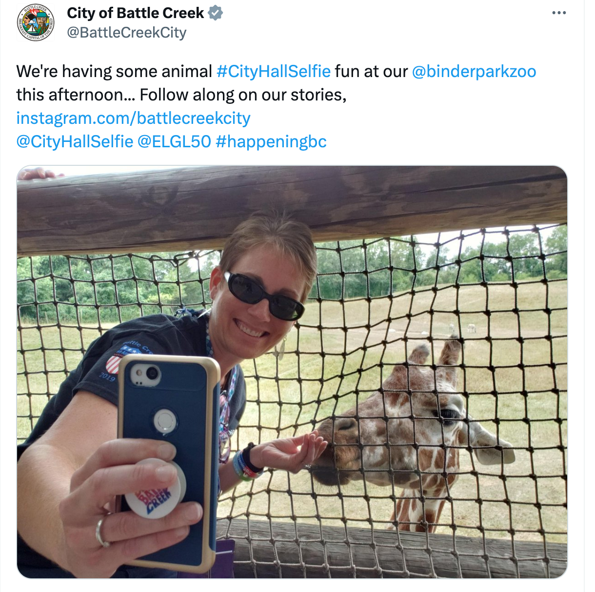 A tweet showing a City Hall Selfie from the City of Battle Creek, MI, zoo featuring a giraffe.