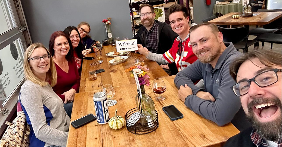 A group of people seated around a table take a selfie during a fall 2023 ELGL Supper Club.