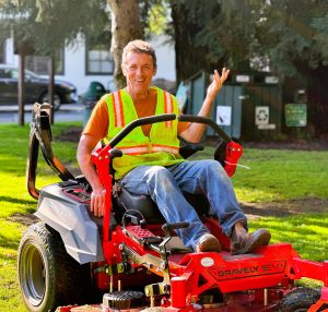 Image of Public Works worker riding an electric lawn mower