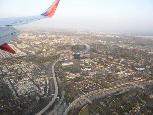 A shot of an airplane flying over the city of Santa Ana on its way to John Wayne airport.