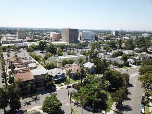 An overhead shot of the residential French Park neighborhood in Santa Ana in the daytime. In the background are tall buildings in adjacent neighborhoods.