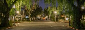 A shot of an intersection, Van Ness Avenue and Russell Avenue in Santa Ana, framed by large trees with leaves that hang over the frame.