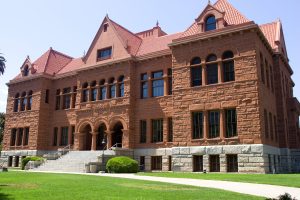 A shot of the old Orange County courthouse building in Santa Ana. It's a stately red brick building with red shingles.