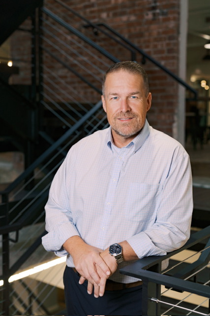 Mayor Suddith leaning against railing.