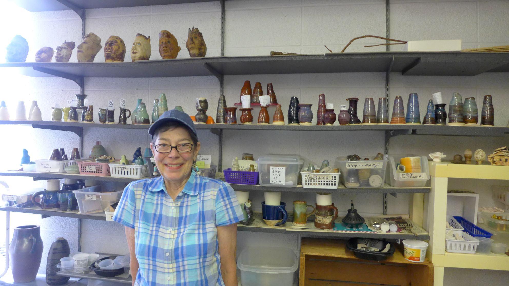 Woman standing in front of ceramic creations.