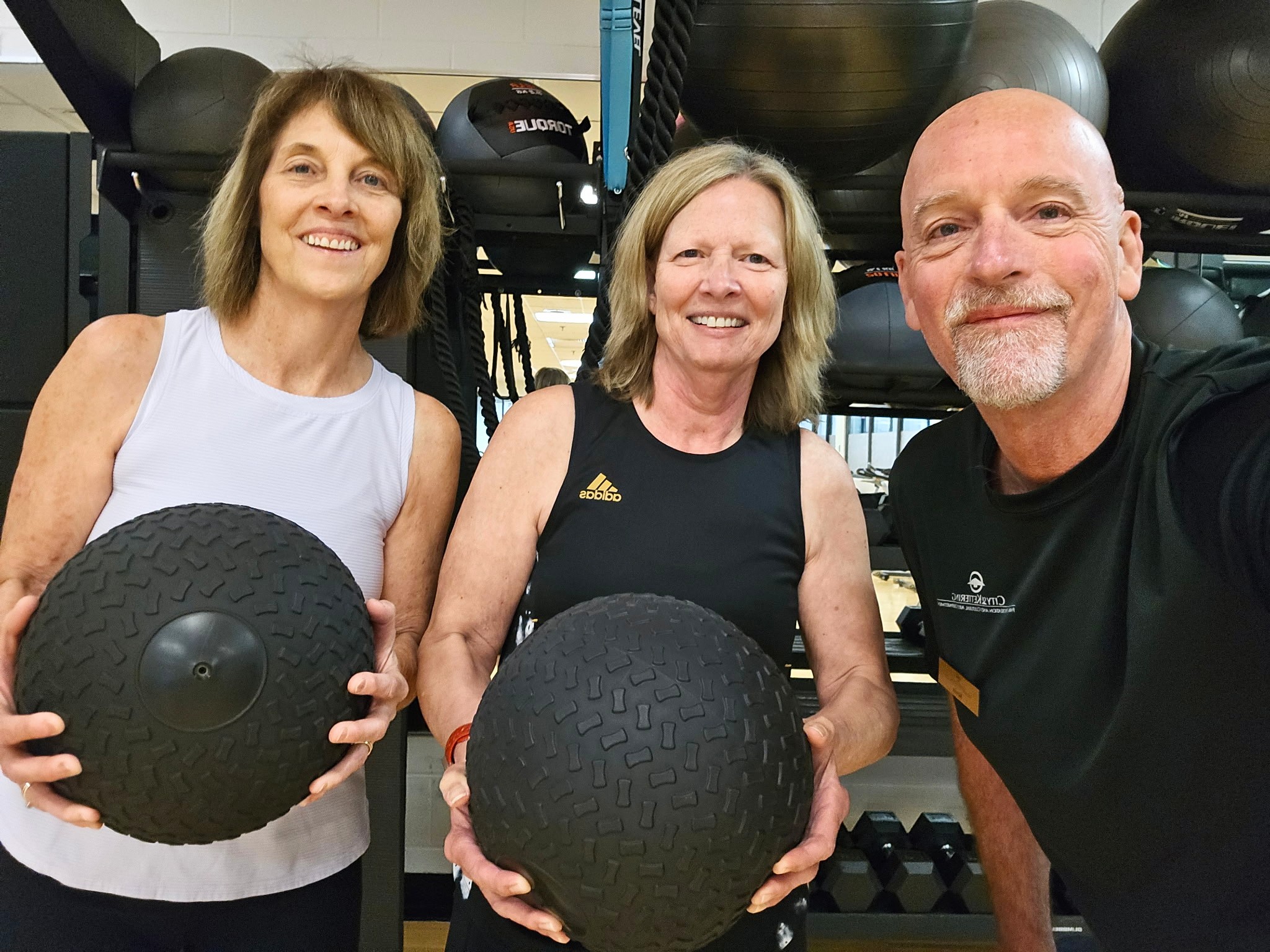 fitness duo Mary and Geralyn posing with trainer Kevin