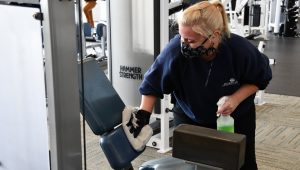 woman cleaning fitness equipment