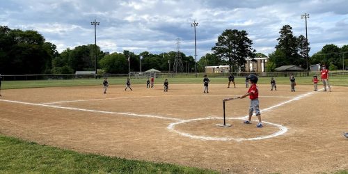 Kids playing baseball cloudy sky