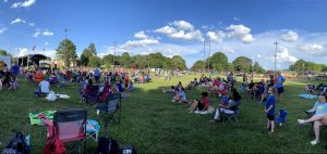 People sitting on lawn at community event