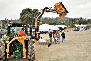 Students at the Public Works Fair watch a public works staff member demonstrate how a piece of heavy equipment functions.