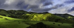 Rolling green hills with dramatic cloud cover