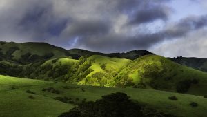 Rolling green hills with dramatic cloud cover