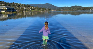 child in rainboots walking through flooded area