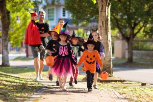 A bunch of kids walking and trick or treating
