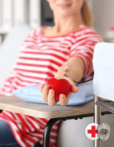 Woman donating blood holding felt heart