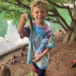 Young boy with a fish on his fishing pole.