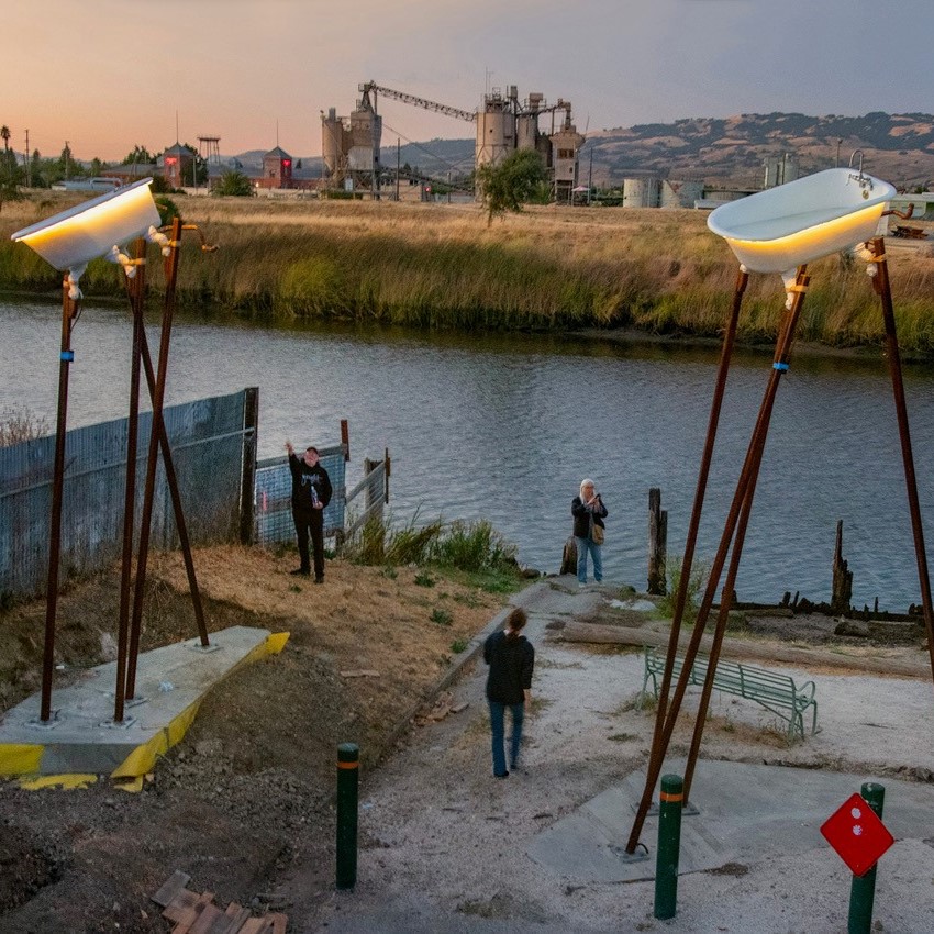 aerial image of an art piece featuring bathtubs on stilts