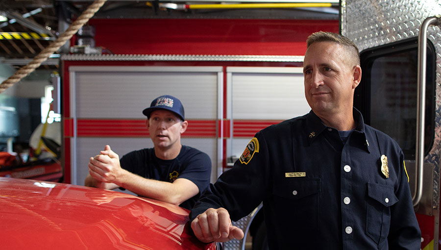 photo of fireman next to fire truck