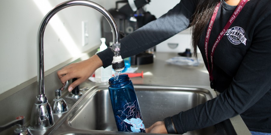 photo of woman filling water bottle