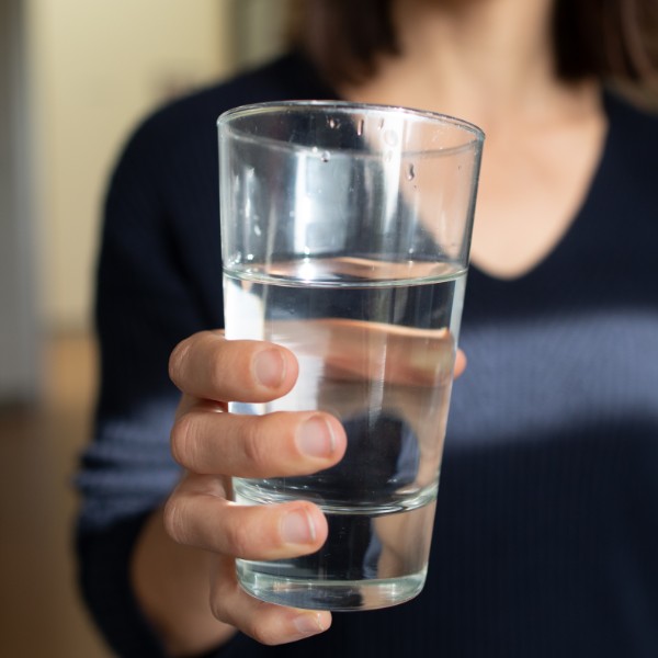 photo of person holding water glass