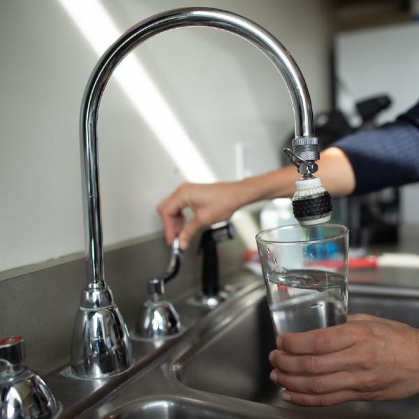 Cup of water under faucet