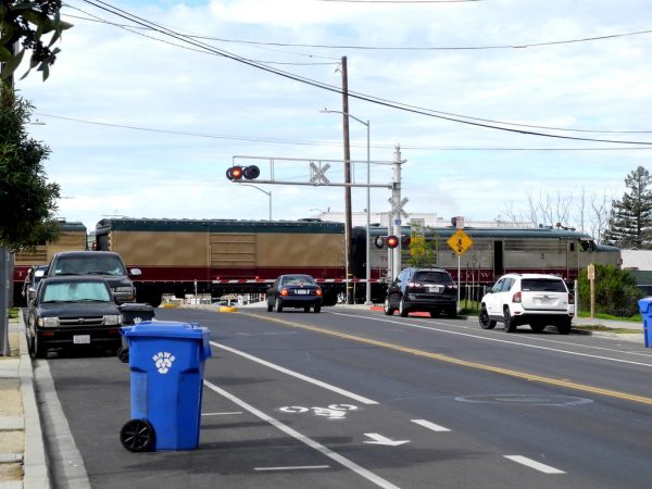 Image of train and cars stopped at stop light