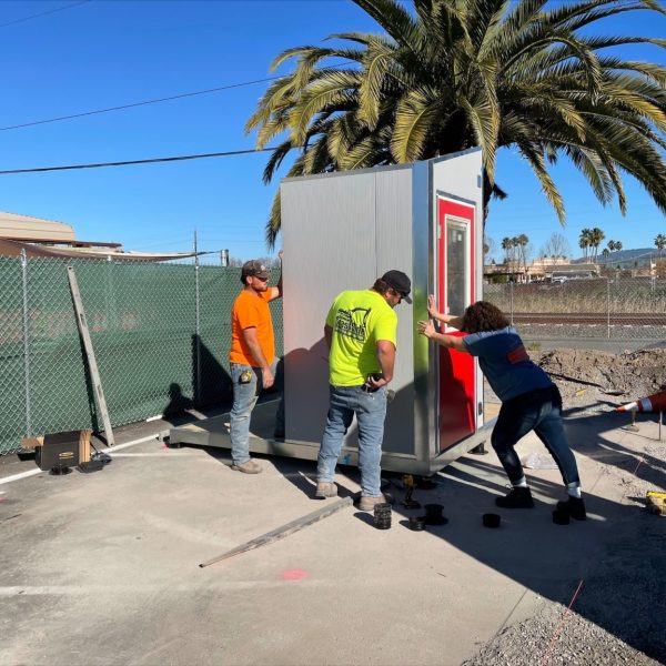 Construction workers moving a tiny home