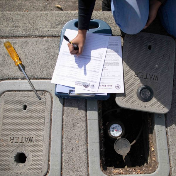 Image of a person inspecting a water meter