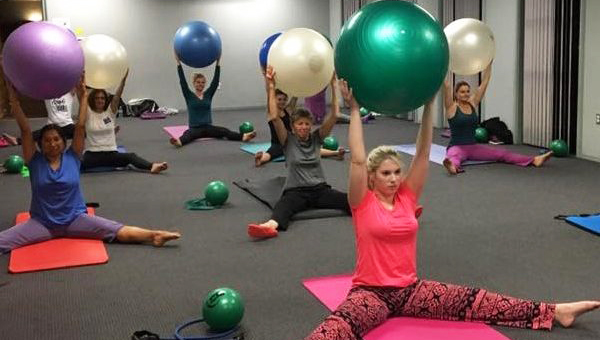 Image of people holding exercise balls at a exercise class