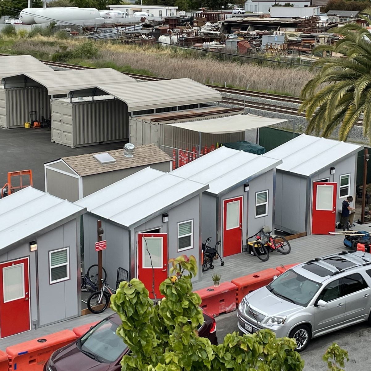 Tiny home village at the Mary Isaak Center. The houses have sloped metal roofs and red doors.