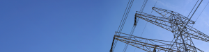 Image shows a powerline against a blue sky.