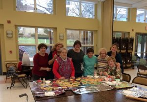 group pictures of 8 members of the senior center posing with decorative cookies