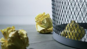 paper balls near trash with one paper ball inside the trashcan