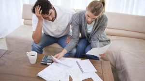 Stressed couple looking at bills.