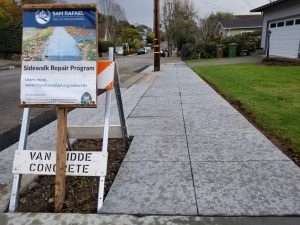 Sidewalk repair program sign along newly repaired sidewalks