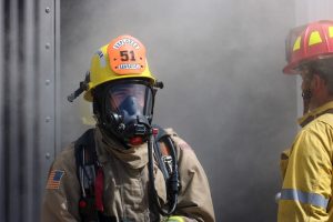 Fire department explorer in front of smoke wearing a respirator
