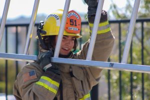 Fire department explorer carrying a ladder