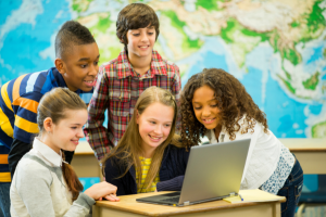 kids in classroom around laptop