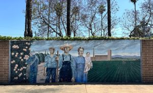 A mural of people on a brick wall.