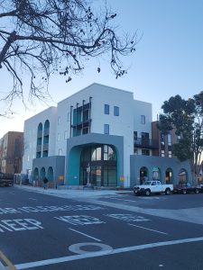 Photo of apartment complex with blue arches and white walls