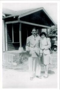 picture of William and Virginia Guzman in front of house