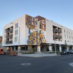 An apartment building with murals on the side.