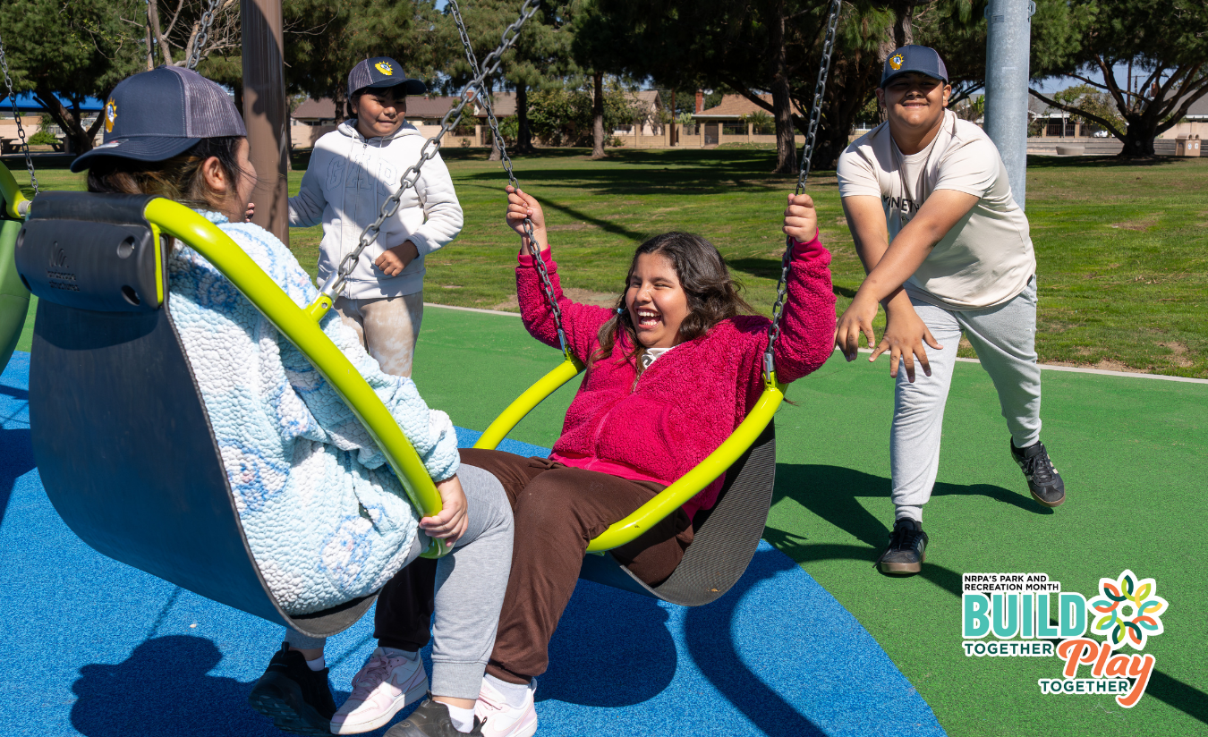 Children playing at the new all access George Upton park playground. Image features the National Park and Recreation Month logo followed by the tagline "Build Together Play Together"