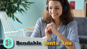 female with headphones in front of laptop with the words