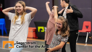 teacher showing kids how dance in a studio with segerstorm center for the arts logo on lower left hand side