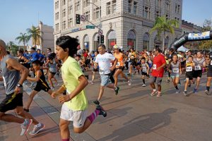 A mass of children and adults running on 4th street