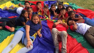 Children playing with a big multicolor parachute